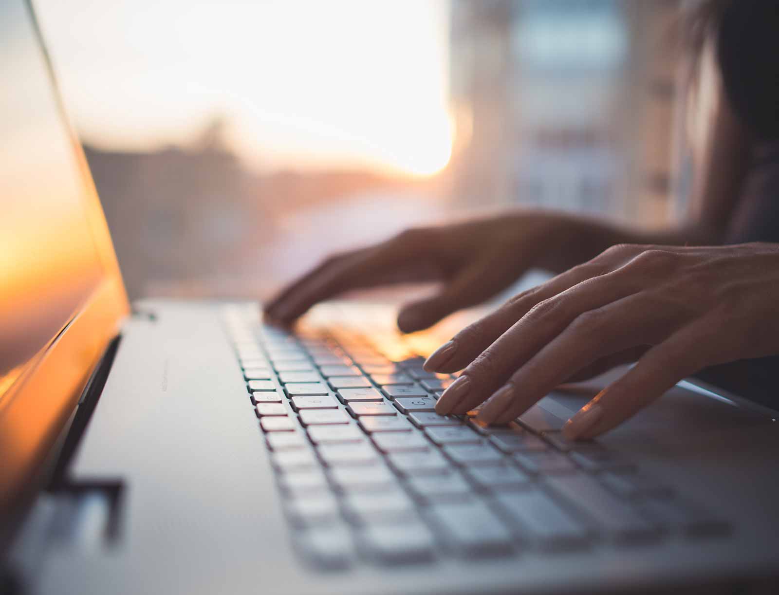 Hands on a laptop keyboard